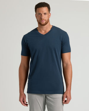 Model in Navy Tall Short Sleeve V-Neck, light gray trousers.