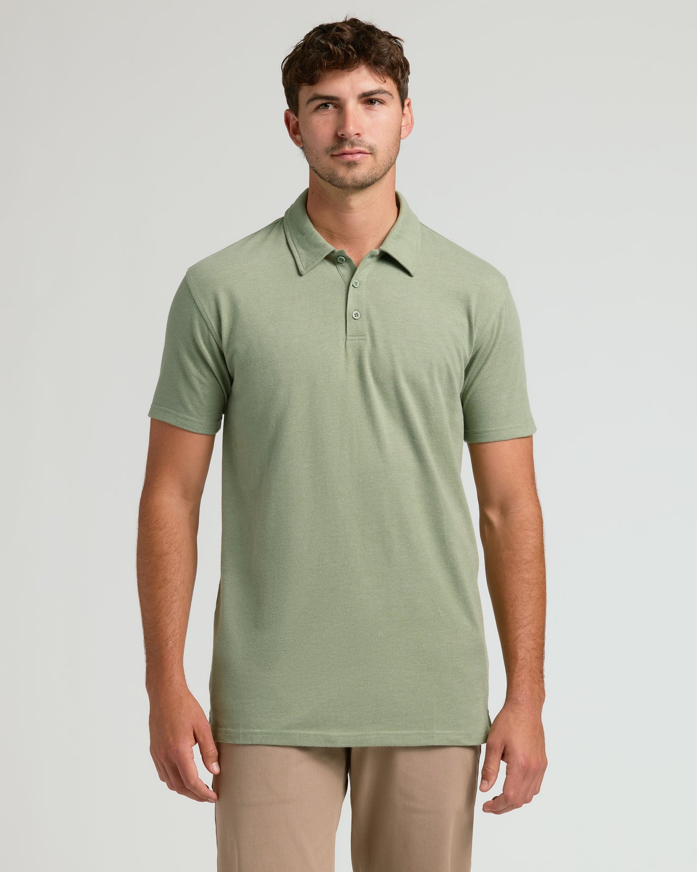 Model wearing Dark Heather Bay Green Short Sleeve Tall Polo, paired with khaki trousers.