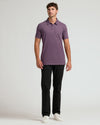 Man wearing Dark Heather Plum Short Sleeve Tall Polo with black pants.