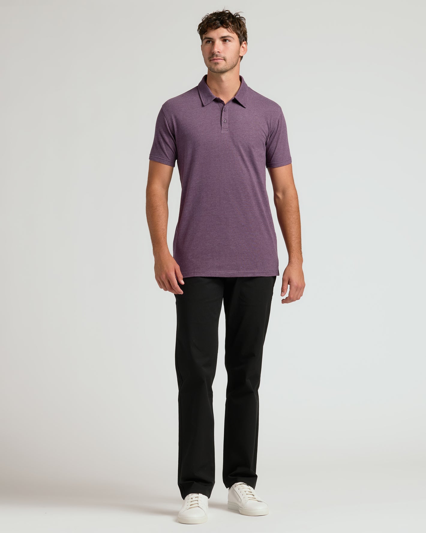 Man wearing Dark Heather Plum Short Sleeve Tall Polo with black pants.