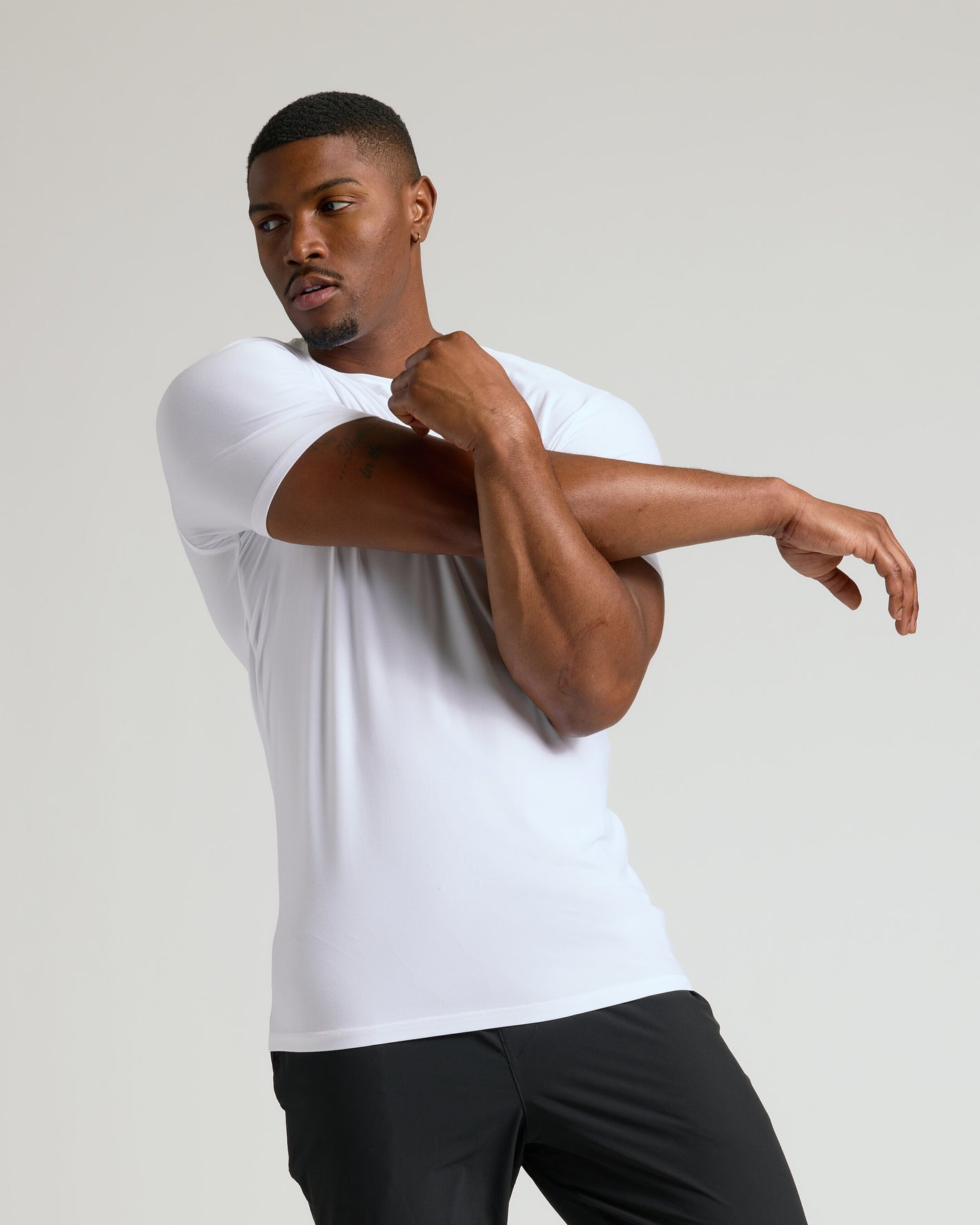 Man stretching in white Neutral Short Sleeve Tall Active Crew shirt.