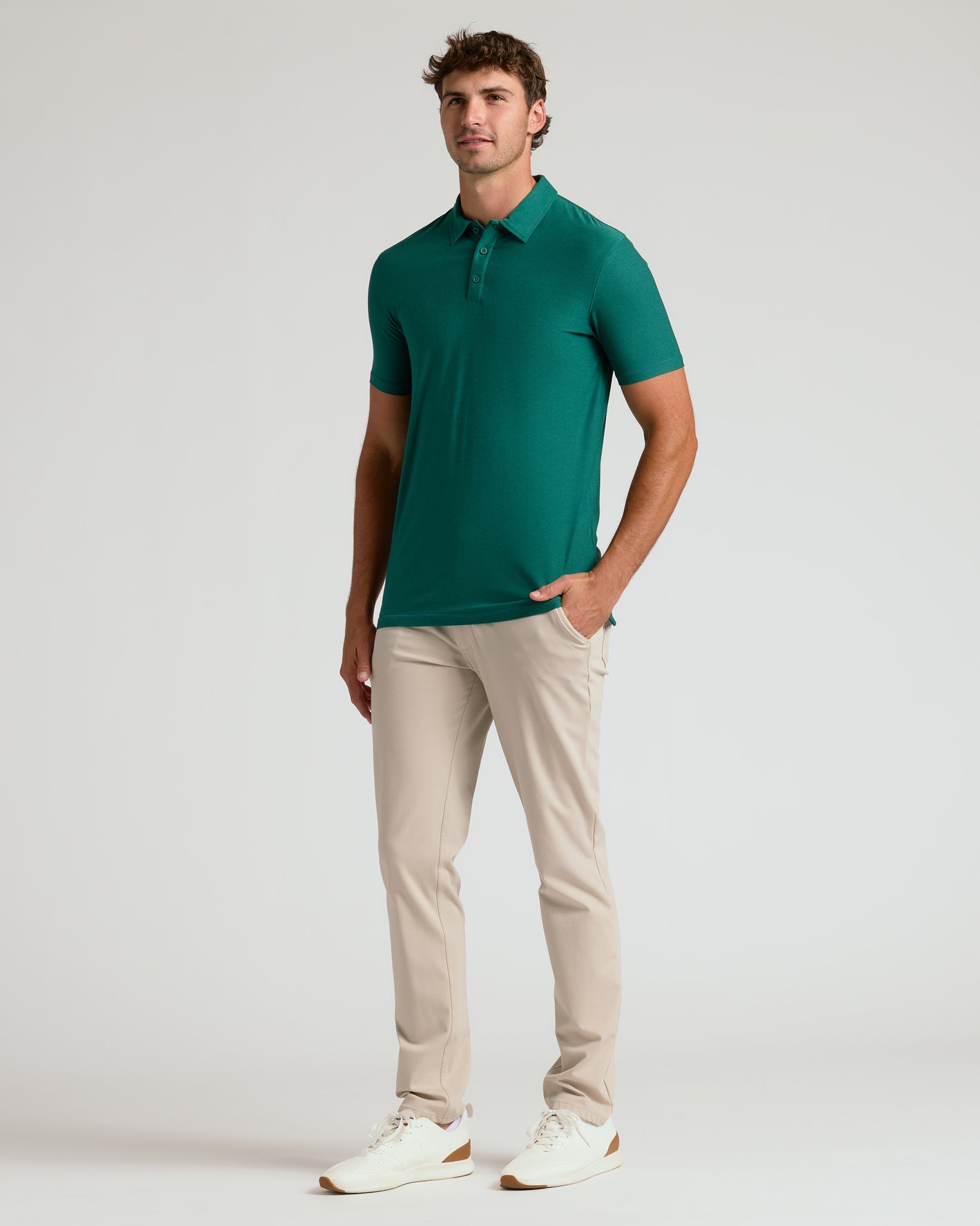 Model in Clover Short Sleeve Tall Active Polo, beige pants, white sneakers.