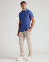 Man wearing Cosmos Short Sleeve Tall Active Polo, beige pants, and white sneakers.