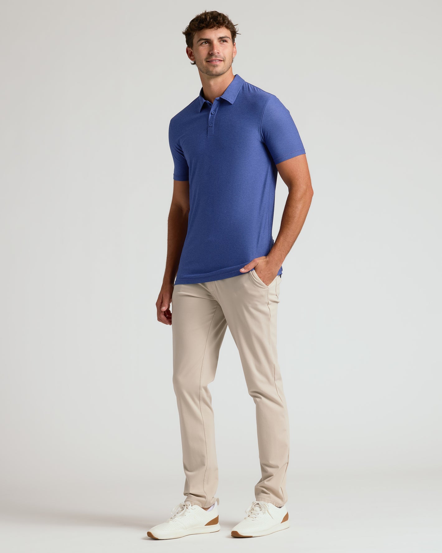 Man wearing Cosmos Short Sleeve Tall Active Polo, beige pants, and white sneakers.