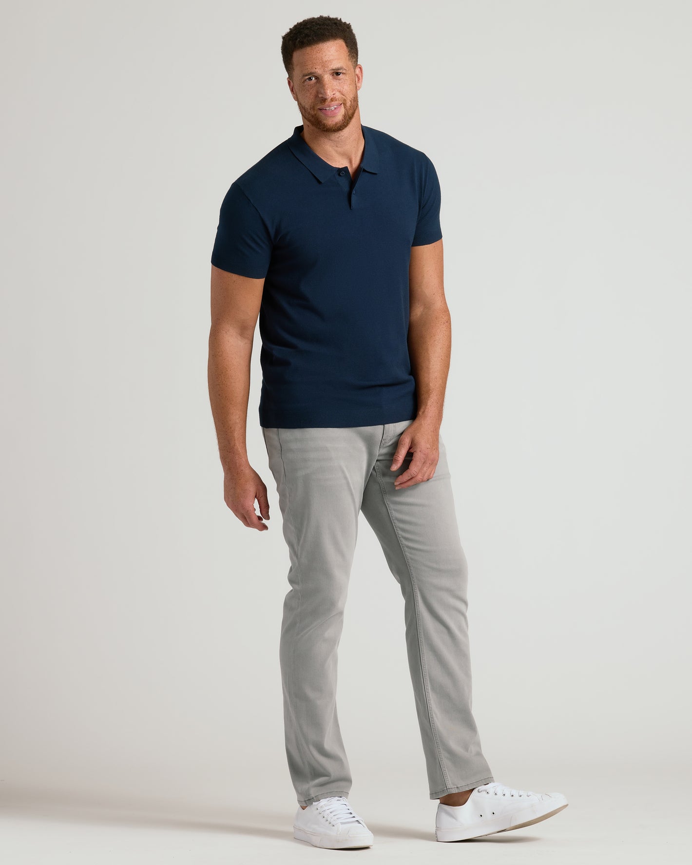 Man wearing Navy Tall Dressy Polo with gray pants and white sneakers.