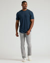 Man in Navy Short Sleeve Tall Curved Hem Crew, slim-fit jeans, sneakers.