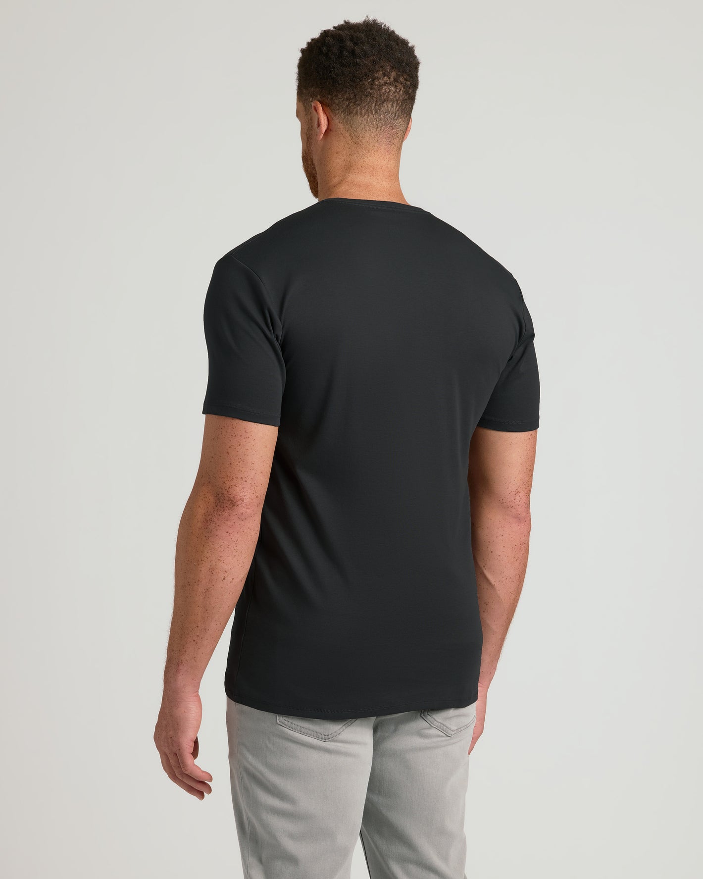 Back view of model in Black Tall Premium Pima V-Neck and gray jeans.