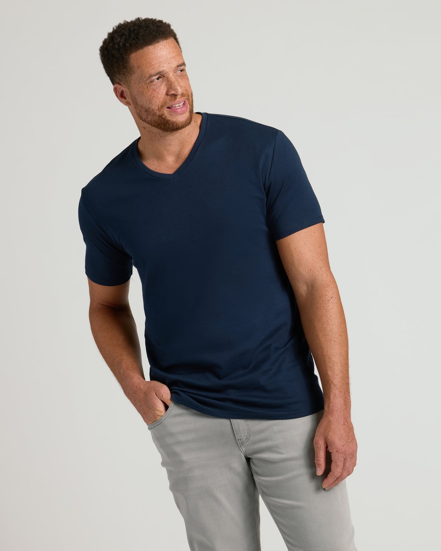 Man wearing Navy Tall Premium Pima V-Neck and gray pants.