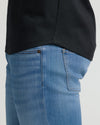 Close-up of a black Tall Pima Cotton Blend Curved Hem Crew 7-Pack shirt worn with light blue jeans, highlighting the curved hem detail in a men's basics style.