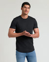 Man wearing a black Tall Pima Cotton Blend Curved Hem Crew 4-Pack t-shirt paired with blue jeans, showcasing a comfortable and fitted men's basics style.