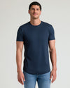 Man wearing a navy Tall Pima Cotton Blend Curved Hem Crew 4-Pack t-shirt paired with light blue jeans, showcasing a clean, fitted men's basics style.