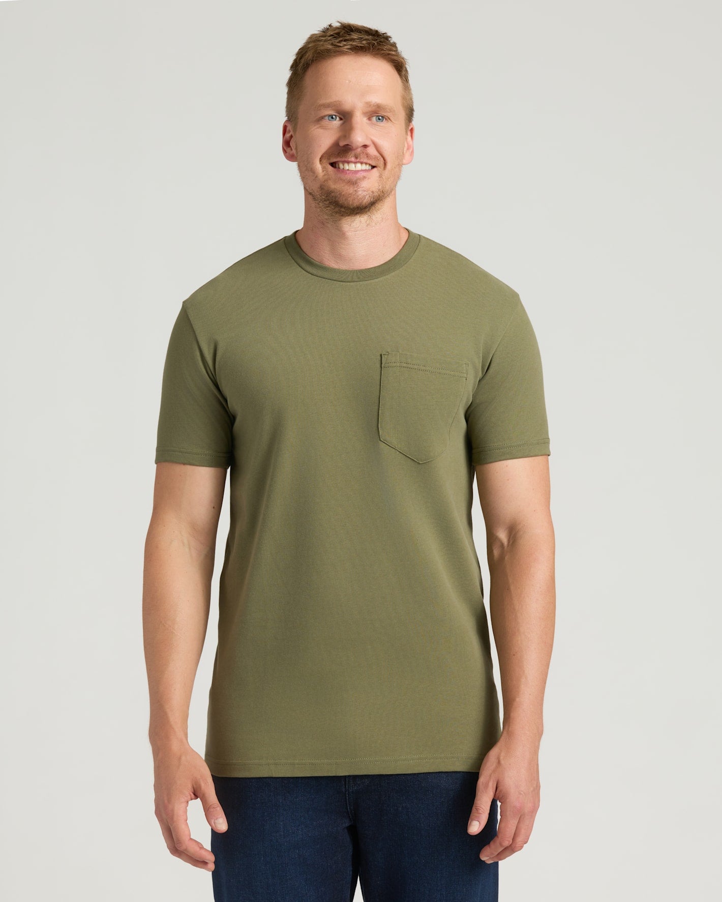 Military Green Tall Heavyweight Pocket Crew on smiling man in dark jeans.