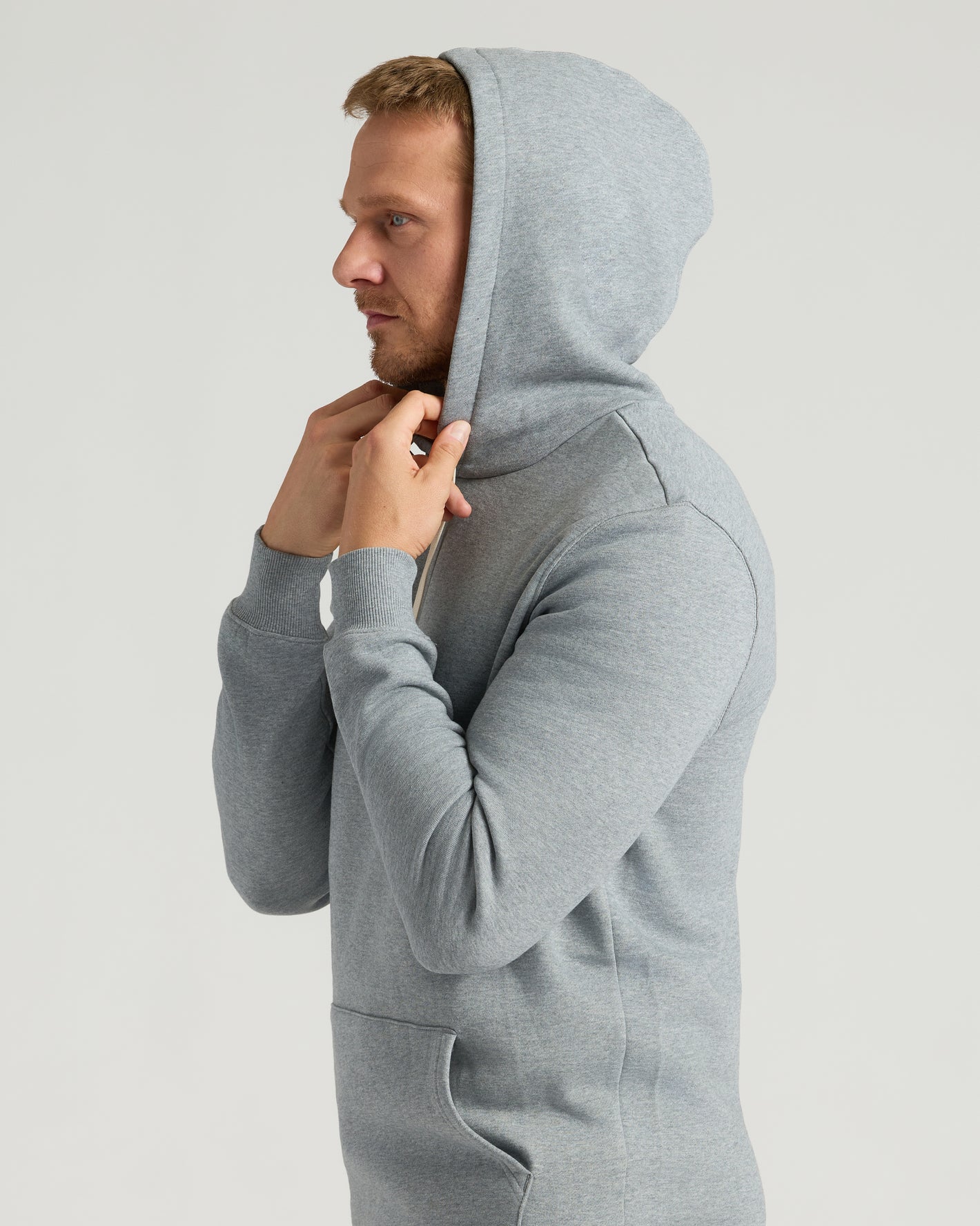 Side-profile of man wearing Medium Heather Gray Tall Fleece French Terry Pullover Hoodie.