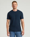 Man wearing a navy blue t-shirt with a pocket on a light gray background