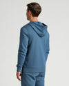 Man wearing a blue Fiord Fleece French Terry Pullover Hoodie shown from the back, highlighting the soft fabric and relaxed fit for casual men's basics.