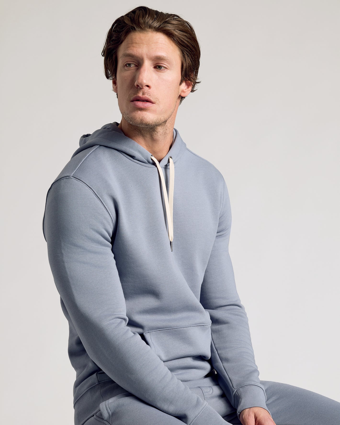 Young man wearing Dusty Blue Fleece French Terry Pullover Hoodie.