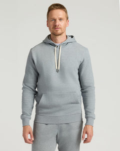 True ClassicA man wearing a Dark Heather Gray Fleece French Terry Pullover Hoodie with a front kangaroo pocket and adjustable cream-colored drawstrings, styled as men's basics.