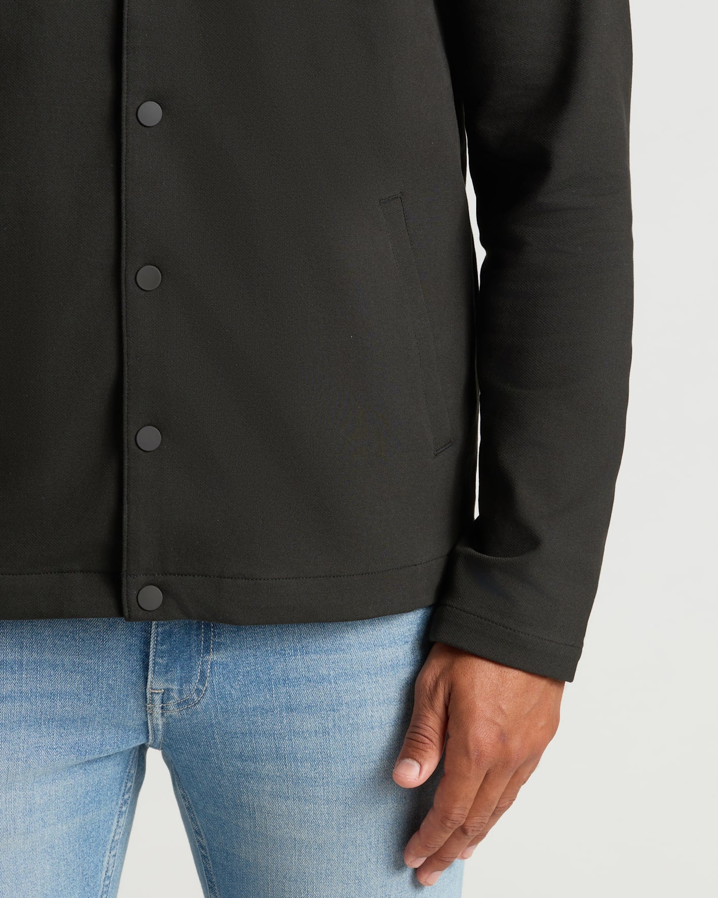Black Casual Jacket over jeans, highlighting its slim fit and structured look.