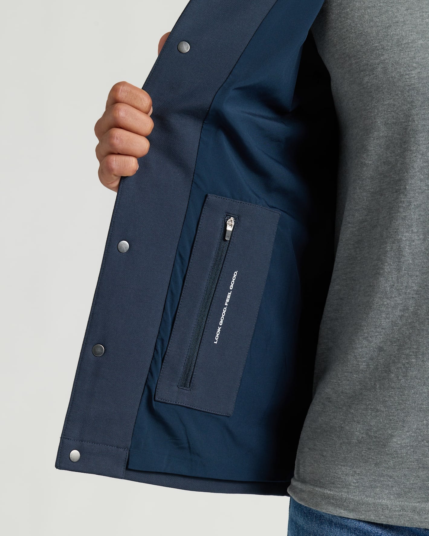 Navy Casual Jacket interior with zip-pocket and slogan, held open.