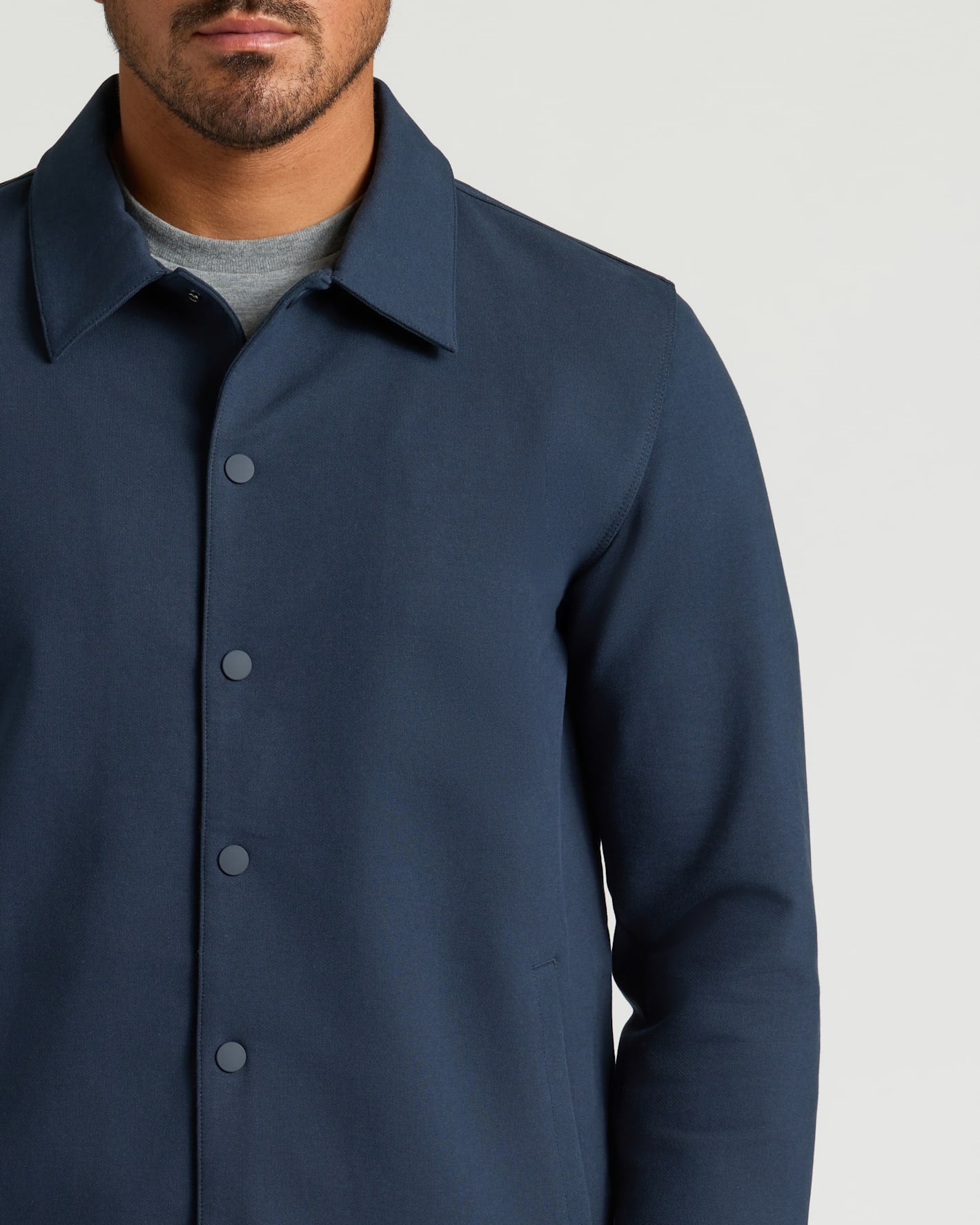 Man wearing Navy Casual Jacket with snap buttons over grey T-shirt.