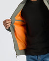 Person wearing Black & Carbon Bomber Jacket, showing orange lining and interior pocket.