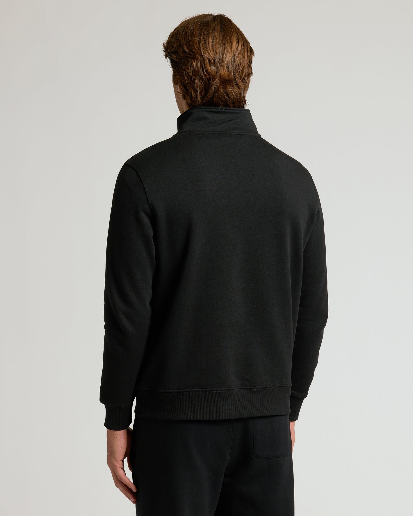 Back view of model in Black Half Zip Fleece Sweatshirt.
