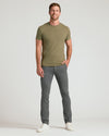 Man wearing Carbon & Khaki Slim Comfort Knit Chino pants, smiling.