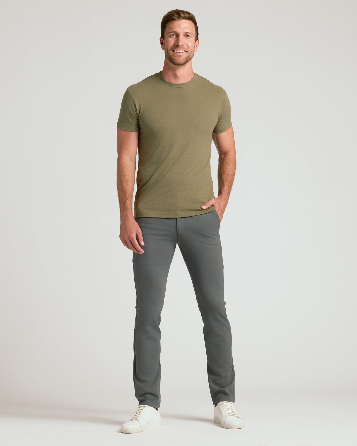 Man wearing Carbon & Khaki Slim Comfort Knit Chino pants, smiling.