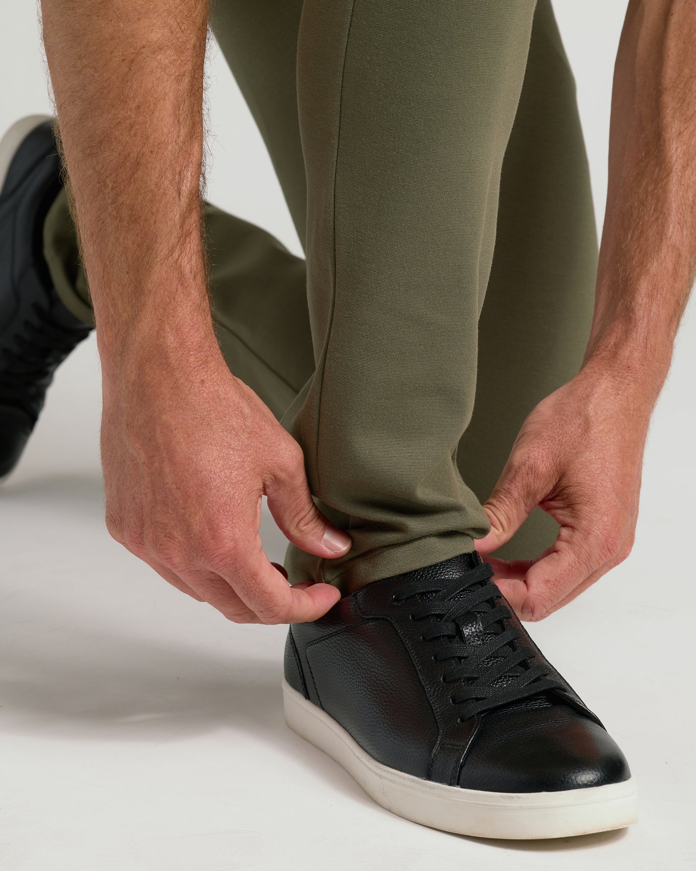 Military Green Slim Comfort Knit Chino Pant worn over black sneaker.