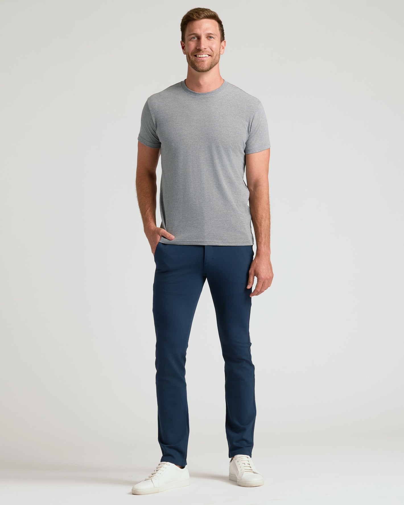 Man wearing Slim Comfort Knit Chino Pant, smiling in casual attire.