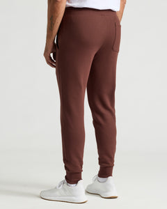 True ClassicCarob Fleece French Terry Jogger with white sneakers, rear view.