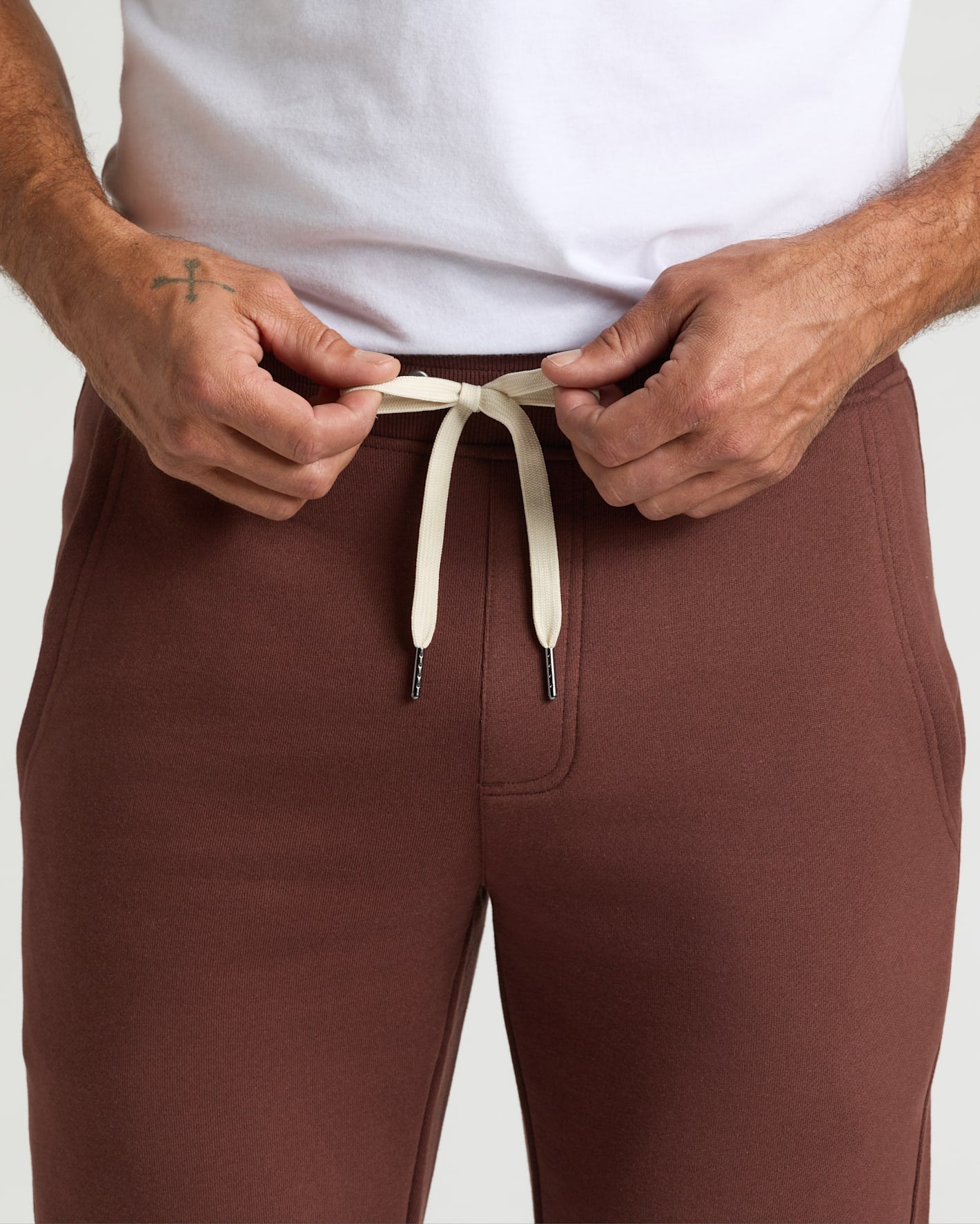 Person tying drawstring on Carob Fleece French Terry Joggers.