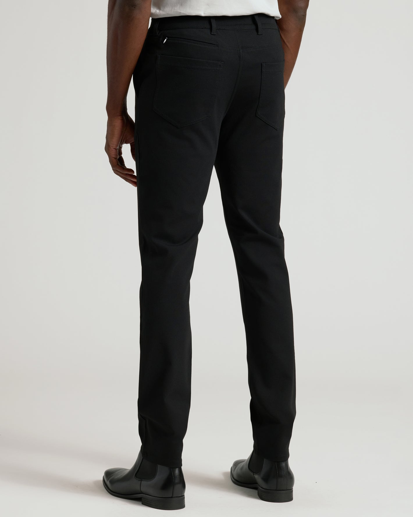 Black Commuter Pants with slim-fit design, paired with black Chelsea boots.