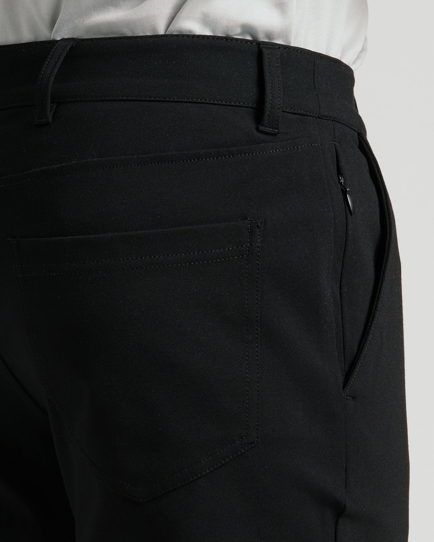 Black Commuter Pants featuring a belt-looped waistband, back patch pocket, and side-seam zippered pocket.