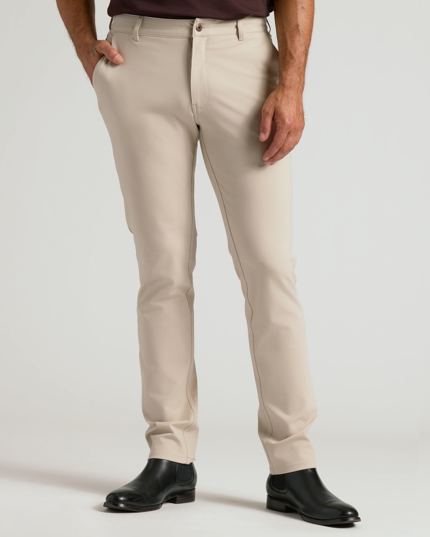 Sandstone Commuter Pants with black Chelsea boots, hand in pocket.