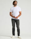 Man modeling Gray Wash Slim Authentic Denim Jeans with a fitted T-shirt.