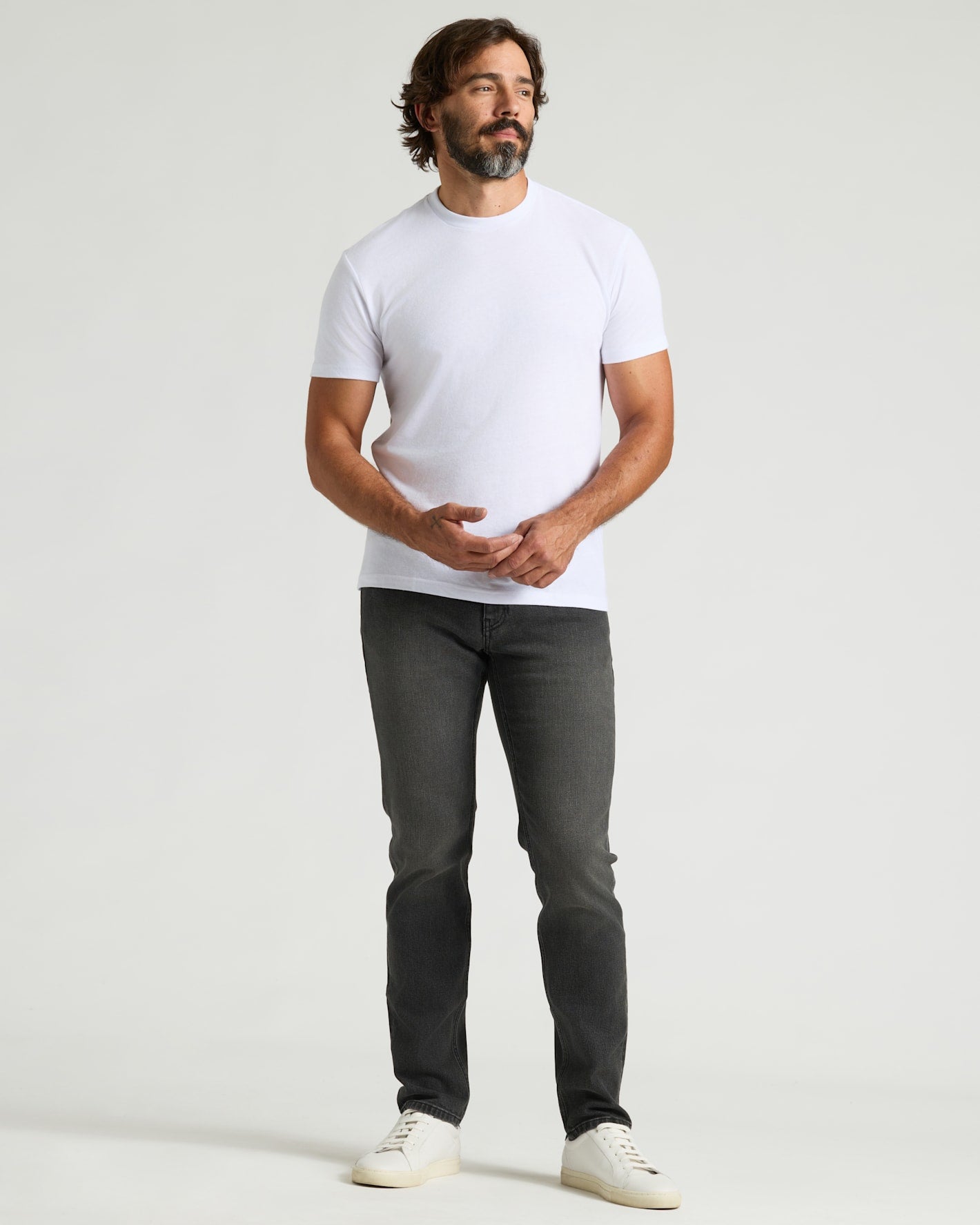 Man modeling Gray Wash Slim Authentic Denim Jeans with a fitted T-shirt.