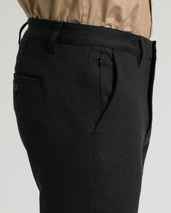True ClassicBlack Slim Chino Pants 2.0 with tucked-in tan shirt, side, and rear pockets.