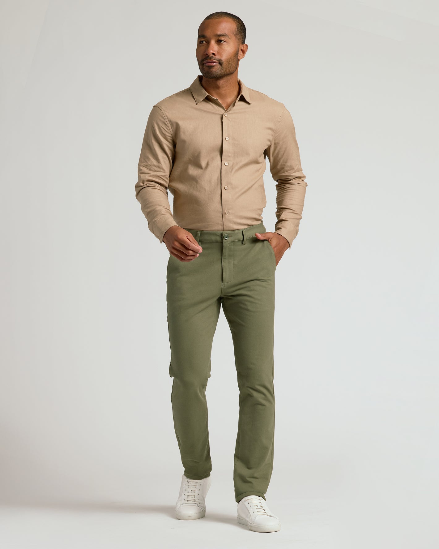 Model wearing Military Green Slim Chino Pants 2.0, mid-stride stance.