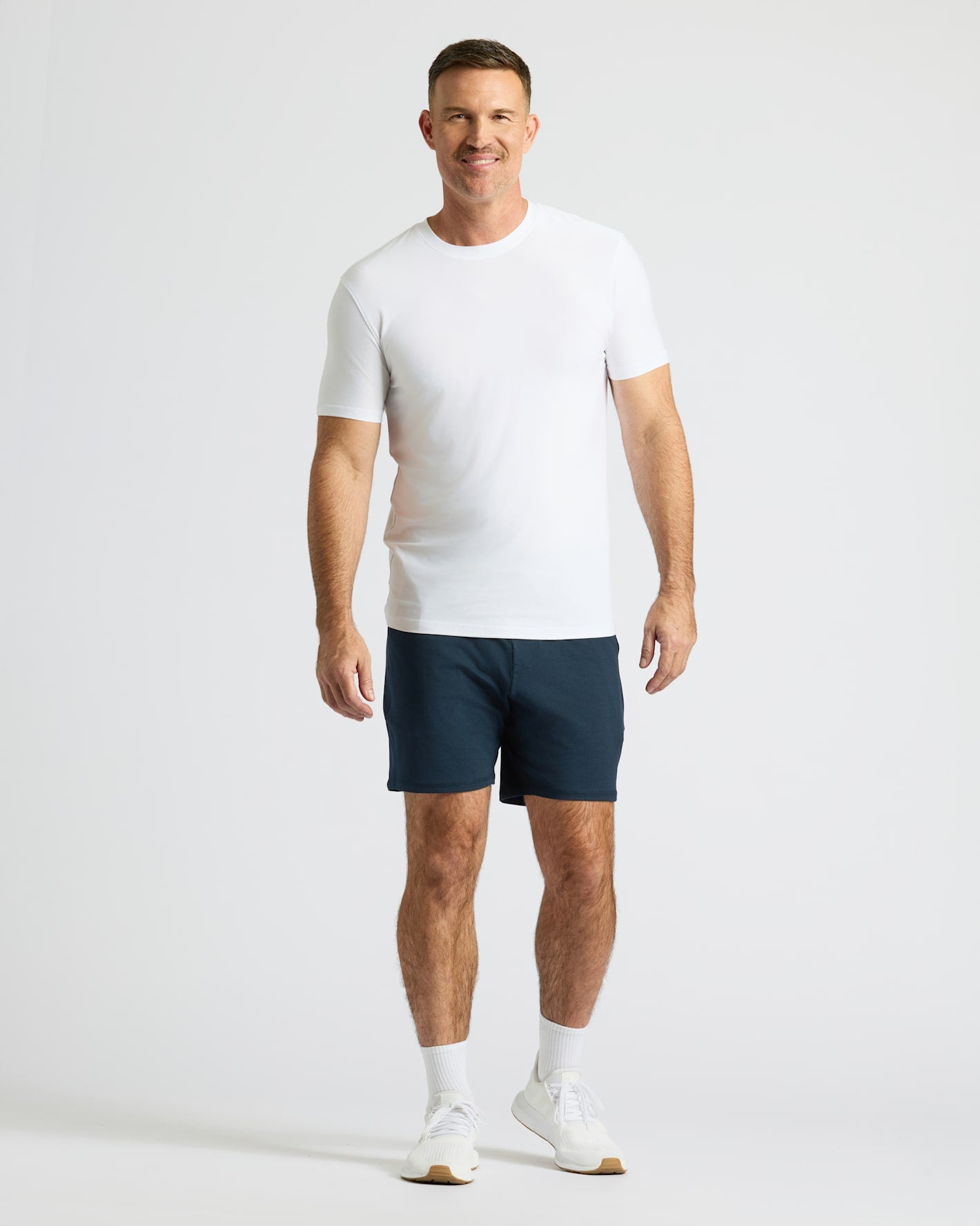 Man wearing Active Comfort Shorts 3-Pack with white T-shirt and sneakers.