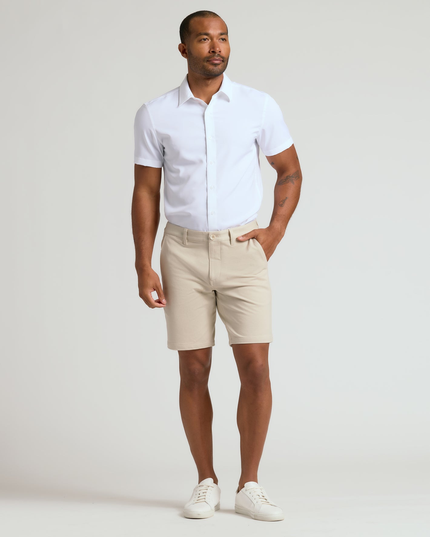 Model wearing 9 Sandstone Chino Shorts 2.0 with white shirt and sneakers.