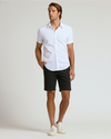 Man wearing 7 Black Chino Shorts 2.0 with white shirt.