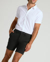 Man wearing 7 Black Chino Shorts 2.0, hand in pocket.