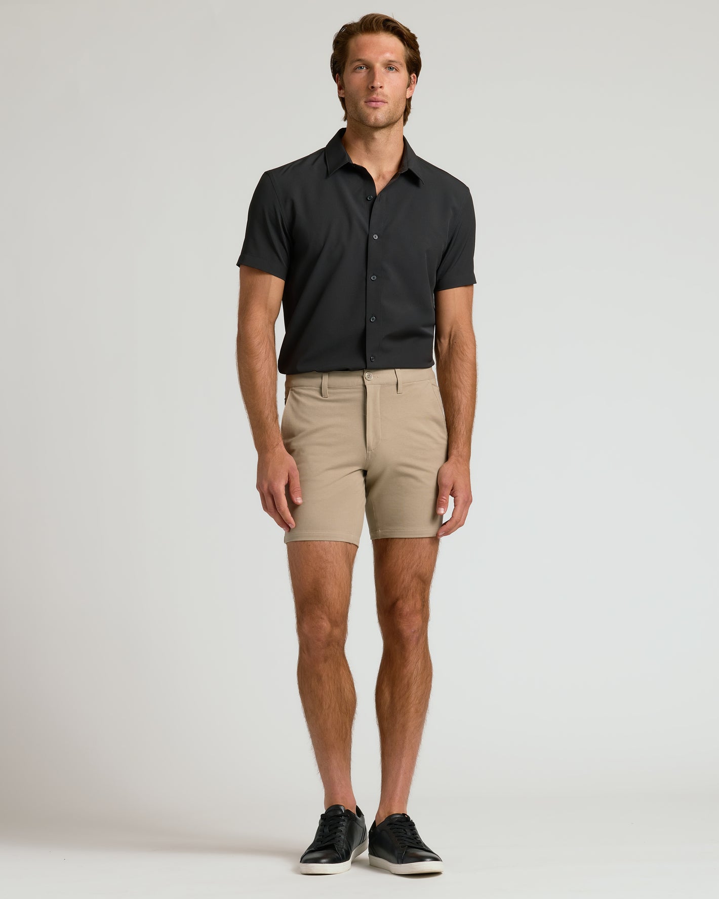 Man wearing 7 Khaki Chino Shorts 2.0 with black shirt.