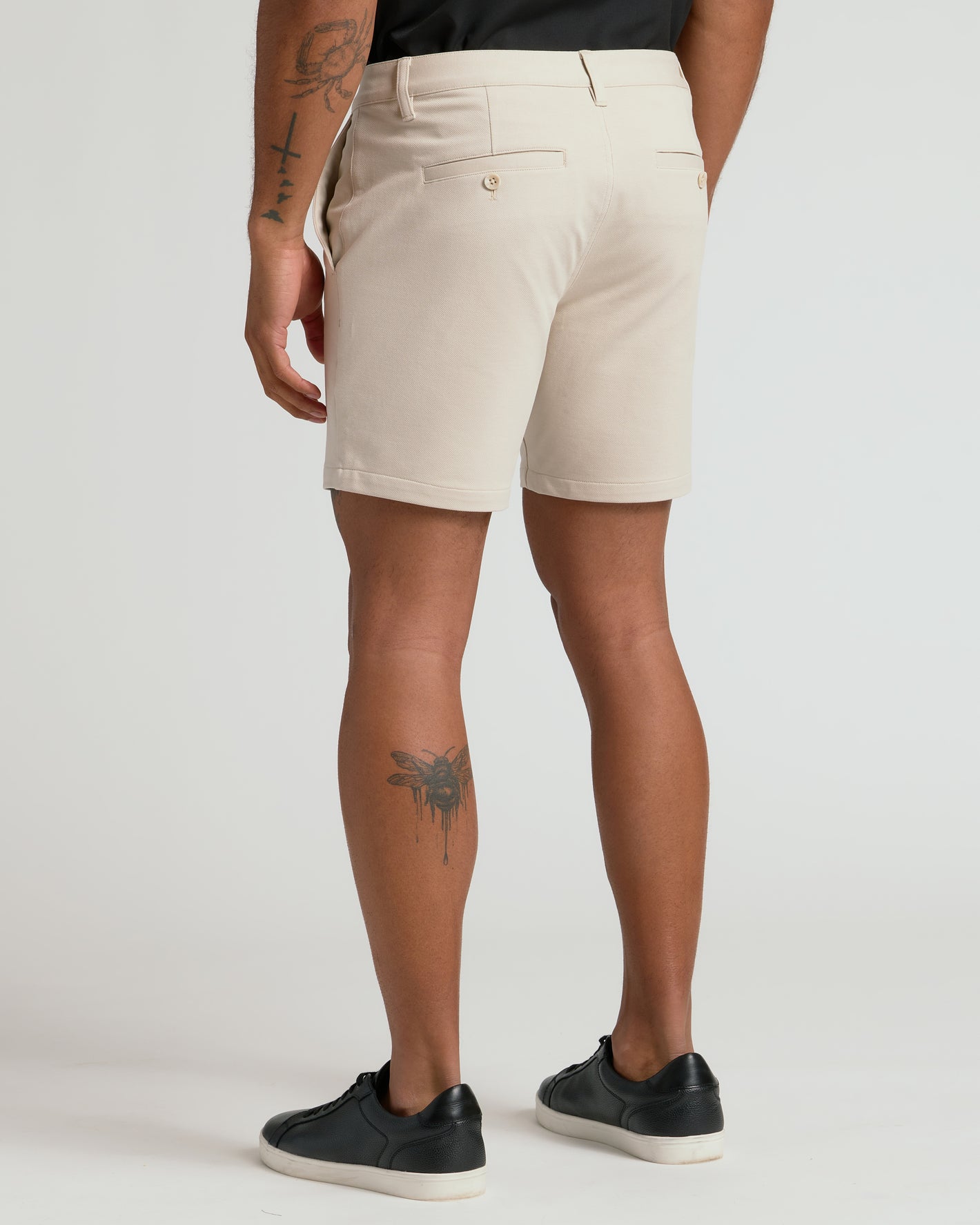 7 Sandstone Chino Shorts 2.0 worn, showcasing tattoos and sneakers.