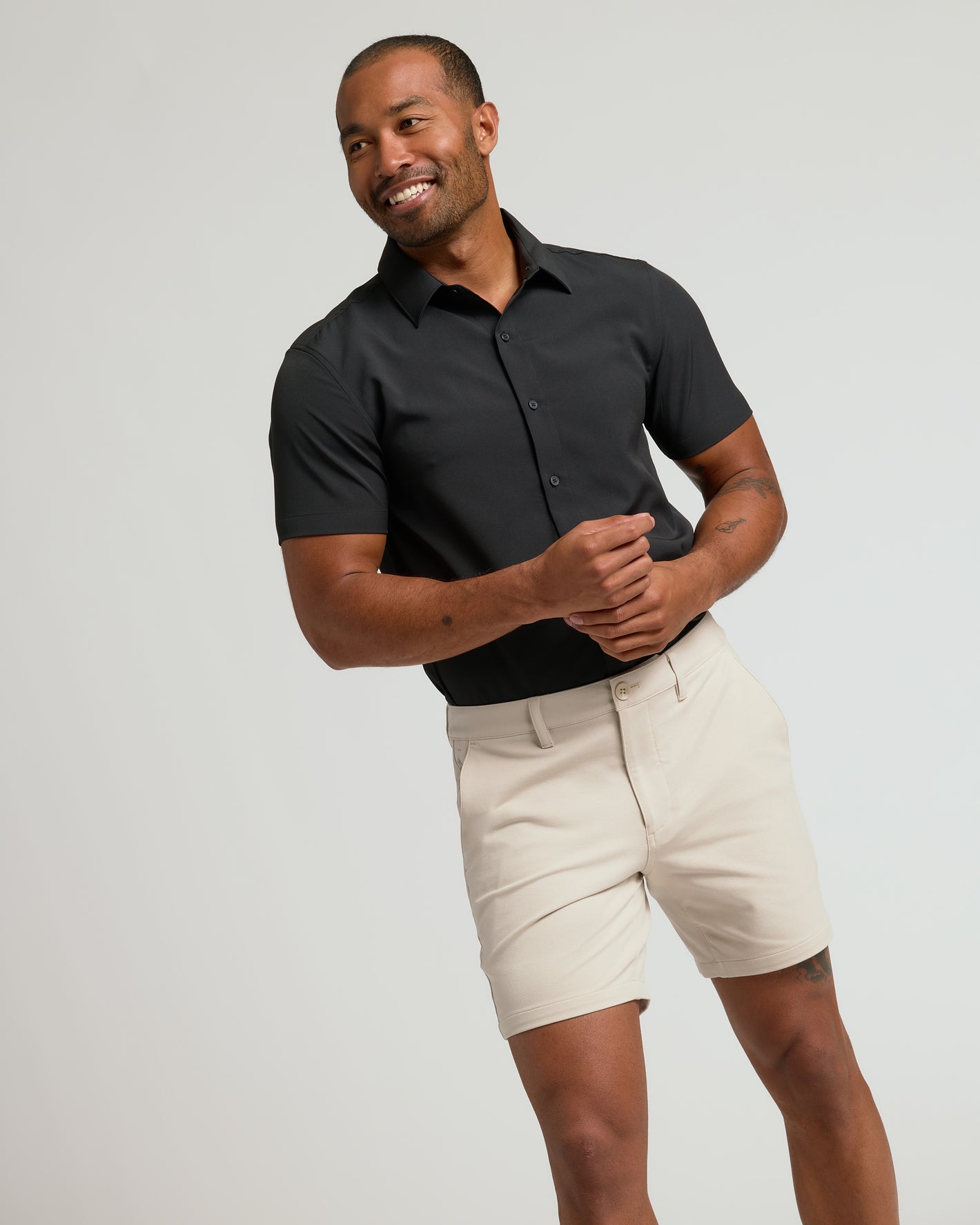 Model wearing 7 Sandstone Chino Shorts 2.0 with black shirt.