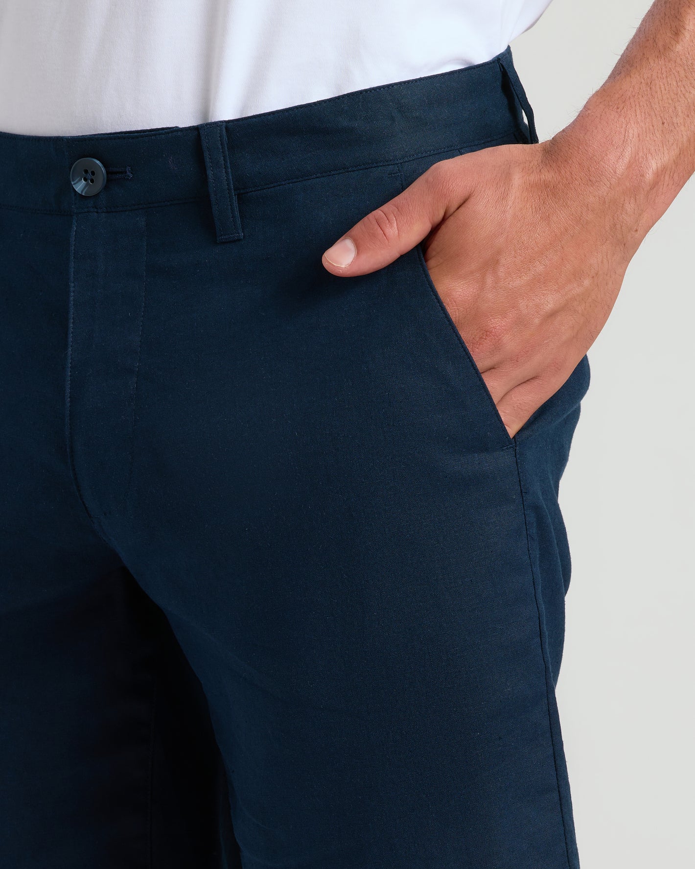 9 Navy Linen Shorts with buttoned waistband, right hand in pocket.