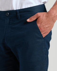 True Classic7 Navy Linen Shorts with hand in front pocket, button visible.