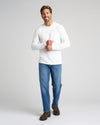 Man wearing True Classic x Timberland Pro Chelsea Boots, smiling against gray background.