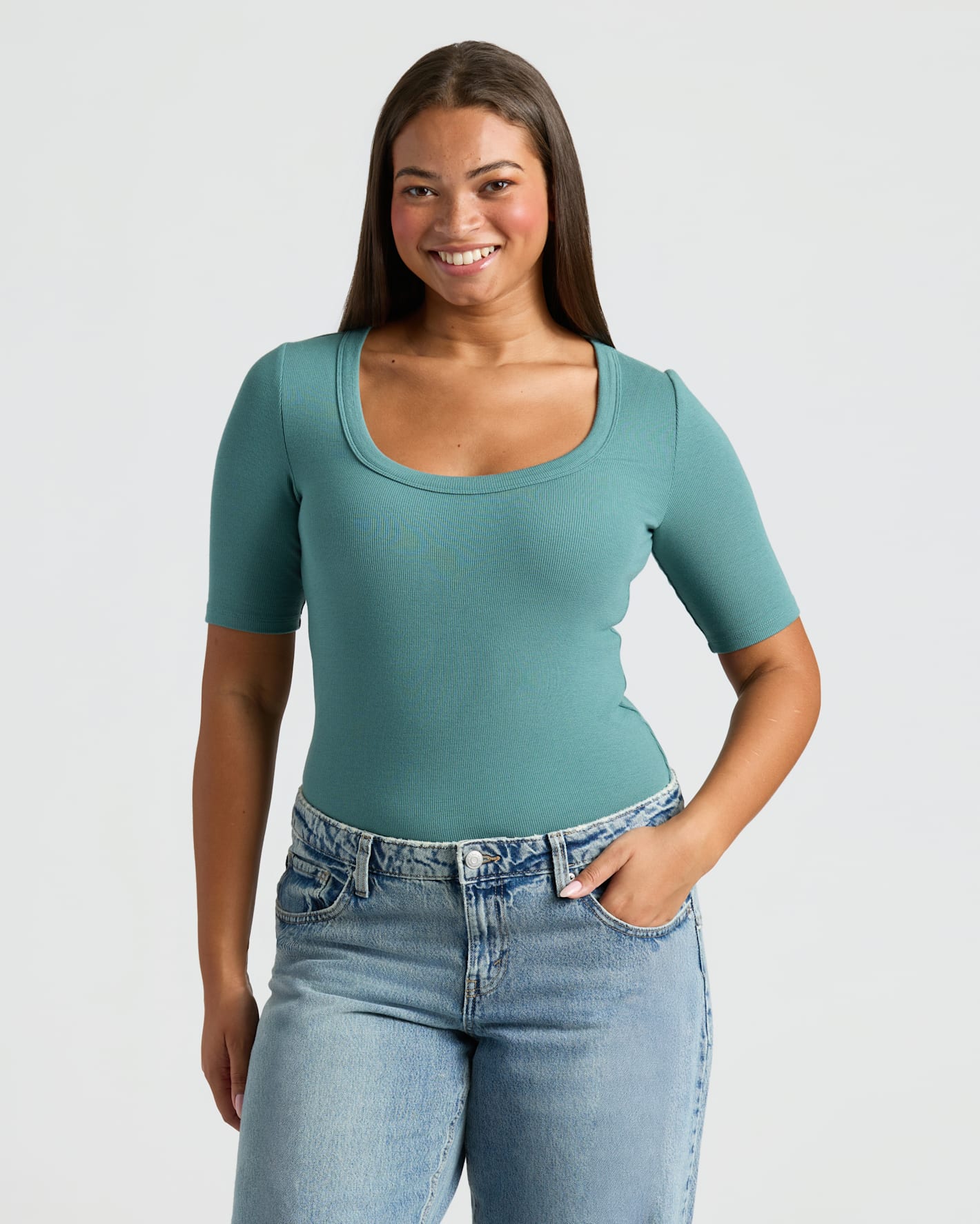 Woman wearing Womens Ribbed 3/4 Sleeve Scoop Neck Tee tucked into jeans.